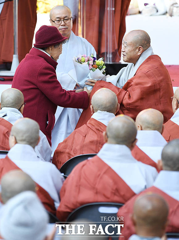 김의정 조계사 신도회장에게 꽃을 선물 받는 원행 스님(오른쪽)