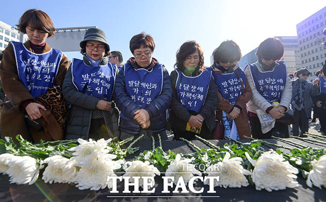 전국장애인부모연대 회원들이 20일 서울 영등포구 국회의사당 정문 앞에서 죽음으로 내몰린 발달장애인 가족에 대한 대책 마련 촉구 기자회견을 열고, 발달장애 자녀를 양육하는 데 어려움을 겪다 지난 15일 목숨을 끊은 한 어머니를 추모하고 있다. /김세정 기자