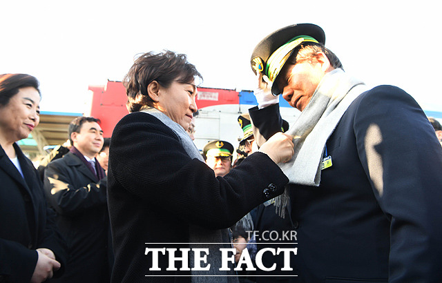 김현미 국토부 장관(왼쪽)이 기관사에게 목도리를 둘러주고 있다.
