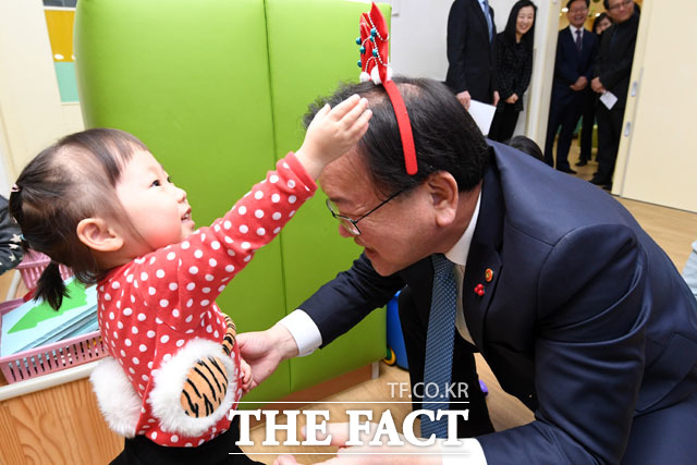 김부겸 행정안전부 장관(오른쪽)이 성탄절을 나흘 앞둔 21일 오전 서울 종로구 정부서울청사 내 어린이집을 찾아 원아들이 씌워준 머리띠를 하고 있다./남윤호 기자