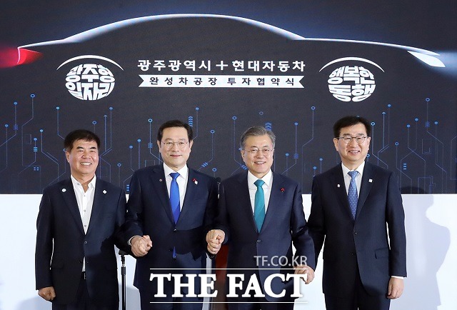 문재인 대통령이 31일 오후 광주광역시 서구 광주시청에서 열린 광주형 일자리 투자 협약식에서 윤종해 한국노총 광주본부장(왼쪽부터), 이용섭 광주광역시장, 이원희 현대자동차 대표이사와 손을 잡고 기념사진을 찍고 있다. /청와대 제공