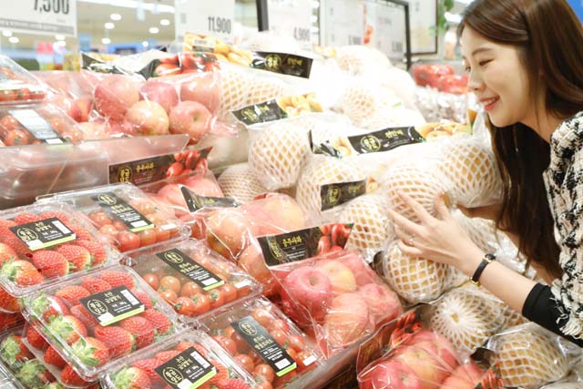 롯데마트는 신선식품 경쟁력 확보를 위해 고당도 등을 고려해 엄선된 황금당도 과일 6종을 출시했다. 한 고객이 매장에서 황금당도 과일을 고르고 있다. /롯데마트 제공