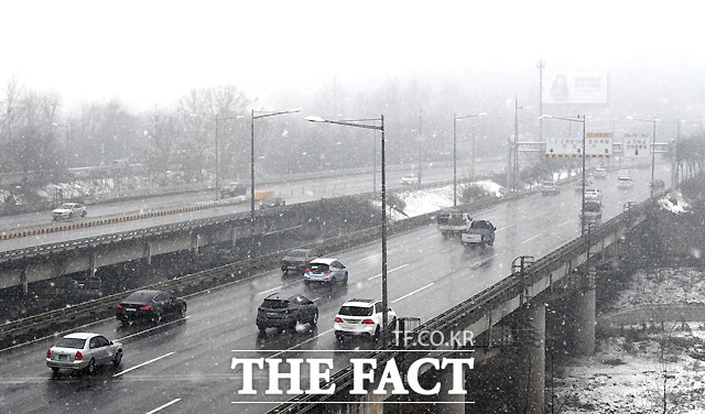 눈 내리는 날씨의 영향으로 차량은 적어 소통이 원활하다.