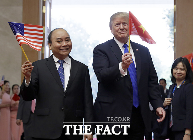 베트남 국기를 든 도널드 트럼프 미국 대통령과 미국 국기를 든 응우옌 쑤언 푹 총리(왼쪽)