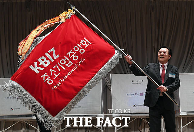 제26대 중소기업중앙회장 선거가 지난달 28일 오후 서울 여의도 중소기업중앙회에서 열린 가운데 결선 투표에서 최고 득표로 당선된 김기문 신임 회장이 깃발을 흔들고 있다./임영무 기자