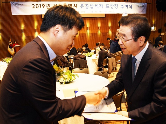 한미약품 이재형 회계팀장(左)이 박원순 서울시장(右)에게 모범∙유공납세 표창을 받고있다. / 한미약품 제공