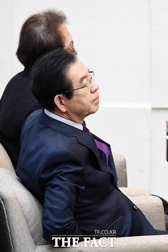 의원들과 인사 후 자리에 앉아 의사일정을 살피는 박 시장