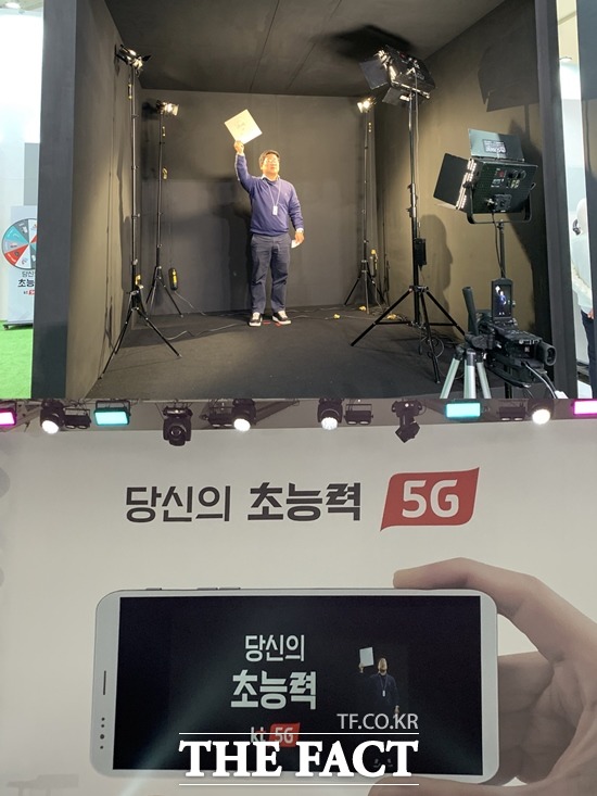 KT는 15일 서울 종로구 광화문 광장에 자사 5G 서비스를 체험할 수 있는 KT 5G 체험관을 열었다. 5G 텔레프레젠스 부스(위)에 있는 모습이 무대 위에 홀로그램 영상으로 옮겨지는 모습. /광화문=서민지 기자