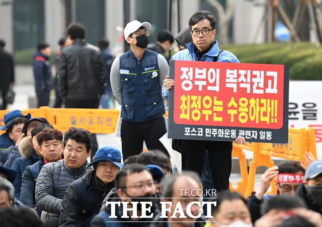 포스코 노조탄압·불법파견 규탄 집회가 15일 오전 서울 강남구 대치동 포스코센터 앞에서 열린 가운데 한 참석자가 정부의 복직권고안 수용을 촉구하는 피켓을 들고 있다. /임세준 기자