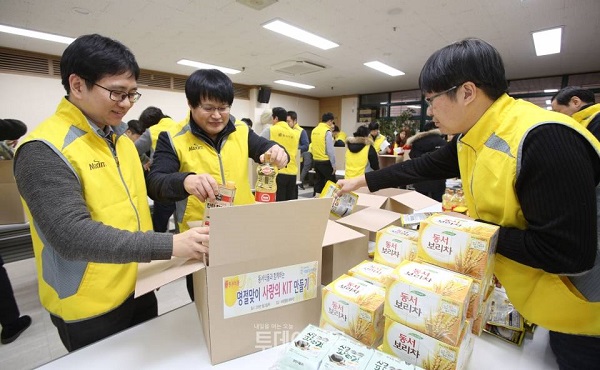 동서식품 임직원들이 모여 소외된 이웃을 위해 보리차˙김˙햄 및 각종 밑반찬 등으로 구성된 식료품세트 200여 개를 포장하고 있다. /동서식품 제공