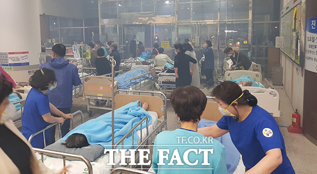 속초의료원으로 불이 번지자 병원 관계자들이 환자를 안전한 곳으로 대피시키기 위해 움직이고 있다.
