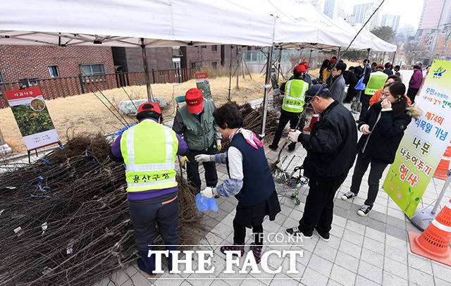 식목일인 5일 오전 서울 용산구 효창공원앞역 광장에서 제47회 식목일 기념 나무 나누어주기 행사가 열린 가운데 시민들이 사과나무 묘목을 받고 있다. /이선화 기자