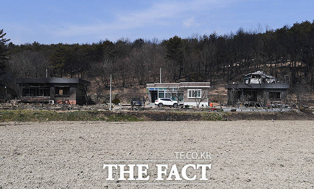 지난 밤 고성에서 시작된 산불이 이어지고 있는 5일 오후 강원도 고성군 토성면 인근 마을의 집이 불에타 검게 그을려 있다. 산 밑에 자리잡은 세집 중 가운데 한집은 다행히 화마를 피해 온전한 모습을 보이고 있다. / 고성=배정한 기자