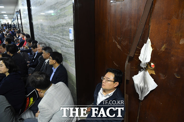 휴식을 취하고 있는 한국당 의원, 보좌진. 그 옆으로 전날 파괴된 의안과 문이 보인다. /배정한 기자