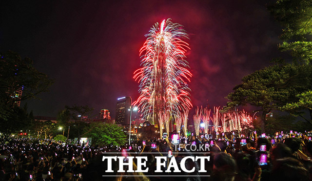 2019 롯데월드타워 불꽃축제가 열린 4일 저녁 서울 송파구에서 위치한 롯데월드타워가 화려한 불꽃으로 밤 하늘을 수놓고 있는 가운데 많은 시민들이 불꽃을 관람하고 있다. /이동률 기자