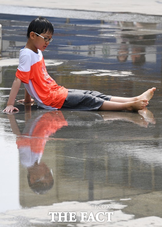 오늘 서울 낮 최고 기온 28도. 낮 기온이 27도까지 오른 지난 12일 오후 서울 종로구 세종대로 광화문광장을 찾은 어린이들이 이순신 동상 앞 분수에서 물놀이들 즐기고 있다. /더팩트 DB