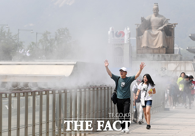 서울 최고기온이 29도까지 오르는 등 무더위 날씨를 보이는 5일 오후 서울 광화문광장을 찾은 시민들이 쿨링 포그를 지나며 더위를 식히고 있다. /남용희 기자