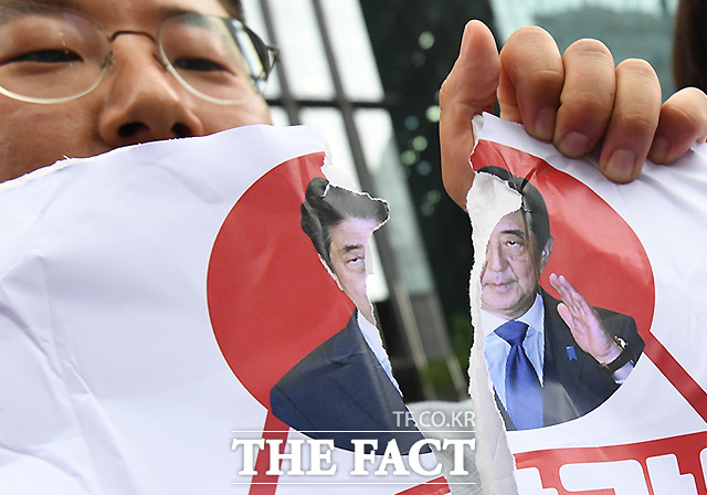 민중당 소속 청년들이 17일 오후 서울 종로구 옛 일본대사관 앞에서 제1396차 일본군 성노예제 문제 해결을 위한 정기 수요집회에 앞서 일본 아베 정권을 규탄하는 퍼포먼스를 하며 아베 총리의 사진을 찢어보이고 있다. /이새롬 기자
