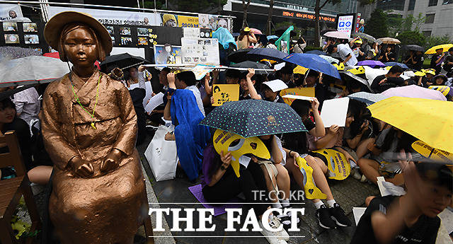 갑작스레 쏟아진 소나기 피하는 집회 참가 학생들