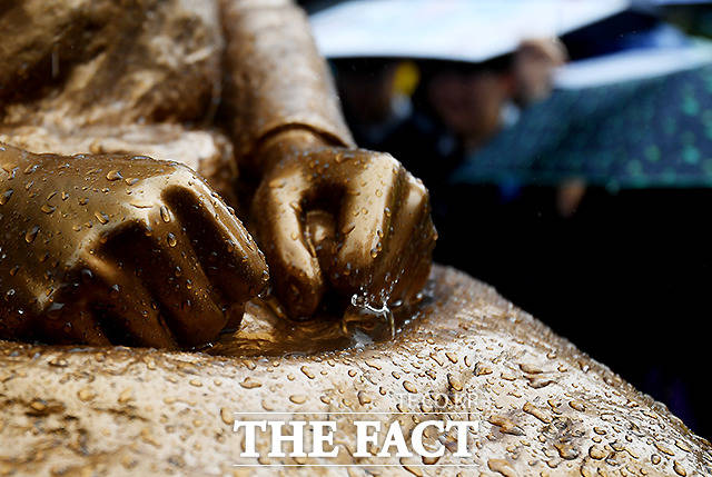 17일 오후 서울 종로구 옛 일본대사관 앞에서 제1396차 일본군 성노예제 문제 해결을 위한 정기 수요집회가 열린 가운데, 갑작스레 내린 소나기가 평화의 소녀상 양손 아래 떨어지고 있다. /이새롬 기자