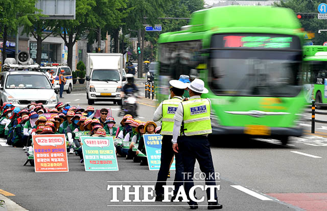 노조원들이 경찰의 협조가 불만족스러운지 행진을 멈추고 도로 위에서 시위를 이어가고 있다.