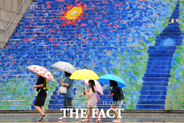 장마전선의 영향으로 서울에 올해 처음 호우경보가 발효된 26일 오전 서울 종로구 세종문화회관 계단 앞에서 우산을 쓴 어린이들이 이동을 하고 있다./남윤호 기자