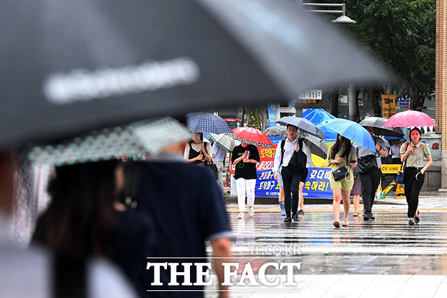 서울을 비롯해 수도권 지역에 호우주의보가 내린 31일 오전 서울 종로구 광화문 네거리에서 시민들이 우산을 쓴 채 발걸음을 제촉하고 있다. /남용희 기자