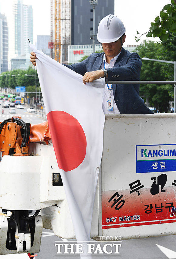 일본이 한국을 전략물자 수출심사 우대국(화이트리스트)에서 제외한 2일 오후 서울 강남구 영동대로에서 강남구청 관계자가 게시된 만국기 중 일장기를 철거하고 있다. /이동률 기자