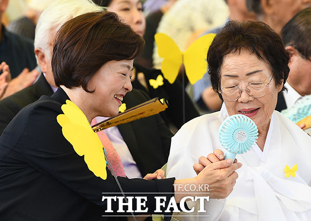 진선미 여성가족부 장관(왼쪽)이 이용수 할머니에게 휴대용 선풍기를 건네주고 있다.