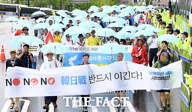 자주와 평화를 위한 8.15 민족통일대회에 참가한 시민들이 하늘색의 평화우산을 들고 일본대사관을 향해 행진하고 있다.