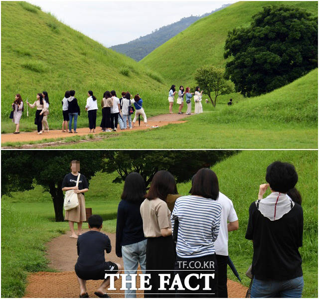 대릉원의 공식 포토존에서 사람들이 줄을 서 사진을 찍고 있다. 포토존은 잔디 사이길에 마련돼 있다.