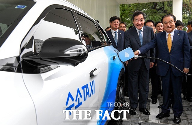 이낙연 국무총리(왼쪽)와 문희상 국회의장이 수소전기택시에 수소를 충전을 하고 있다.