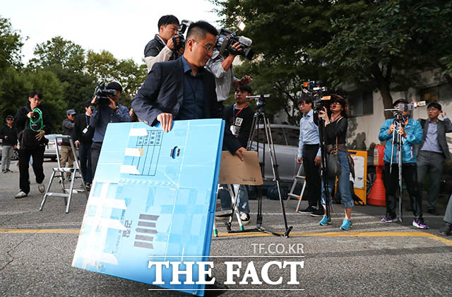 검찰 수사관이 23일 오후 서울 서초구 방배동 조국 법무부 장관 자택 압수수색을 하기 위해 상자를 들고 아파트 현관으로 들어서고 있다./김세정 기자