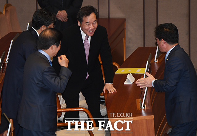 이낙연 국무총리(가운데)가 30일 오전 서울 여의도 국회에서 열린 본회의에 참석해 의원들과 인사하며 환한 미소를 짓고 있다. / 국회=배정한 기자