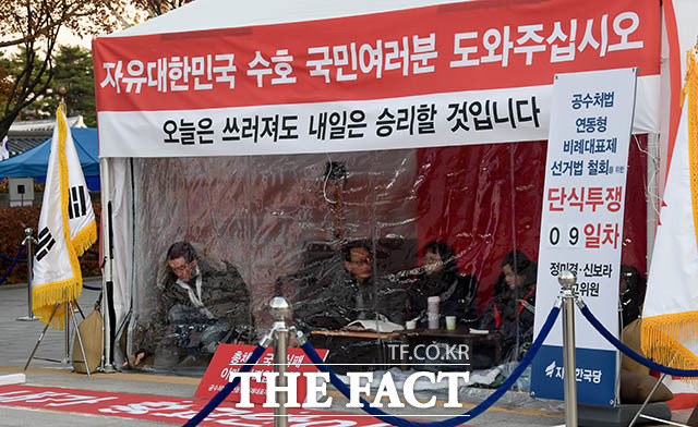 자유한국당 정미경 최고위원(가운데)과 신보라 최고위원(오른쪽)이 28일 오후 황교안 대표가 단식하며 머물던 청와대 앞 천막에 들어가 동조 단식에 참여하고 있는 가운데 한 관계자(왼쪽)가 방한용 비닐의 지퍼를 닫고 있다. /김세정 기자