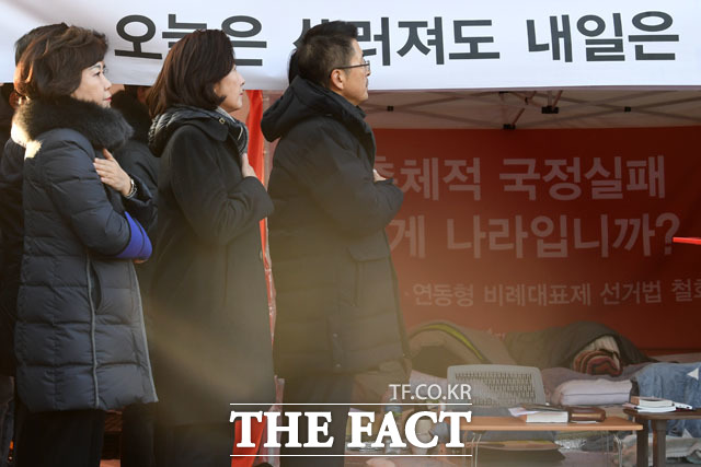 황교안 자유한국당 대표(가운데)와 나경원 원내대표를 비롯한 지도부가 2일 오전 서울 종로구 청와대 사랑채 앞에 마련된 단식 투쟁 천막에서 최고위원회의를 열고 국민의례를 하고 있다./남윤호 기자