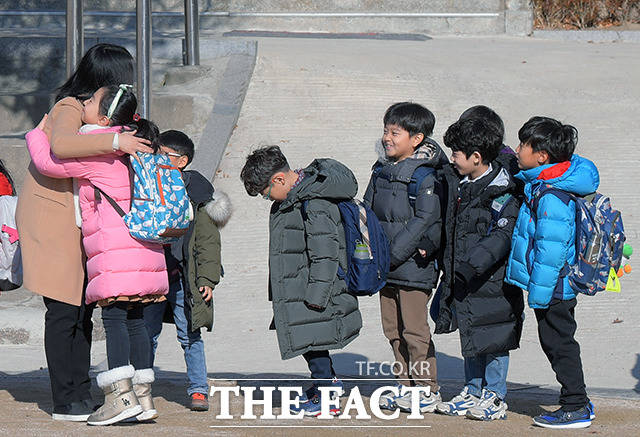 20일 오전 서울 용산구 서울삼광초등학교에서 겨울방학식을 마친 학생들이 하교를 하기 전 담임선생님과 포옹하고 있다. /이선화 기자