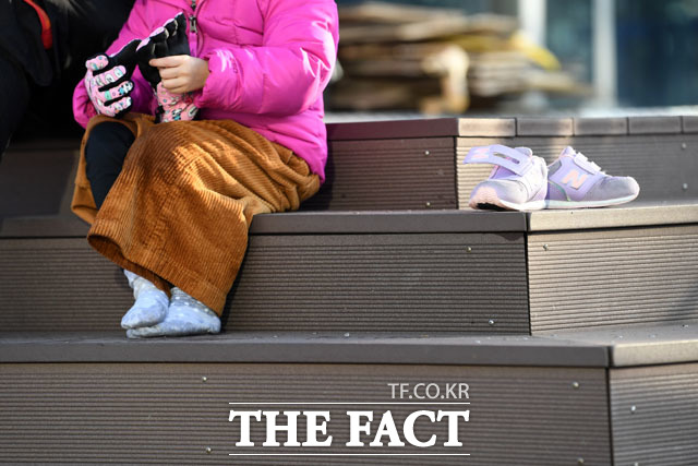 24일 오후 서울 광진구 뚝섬한강공원에 야외 눈썰매장이 개장한 가운데 한 어린이가 신발을 말리고 있다./남윤호 기자