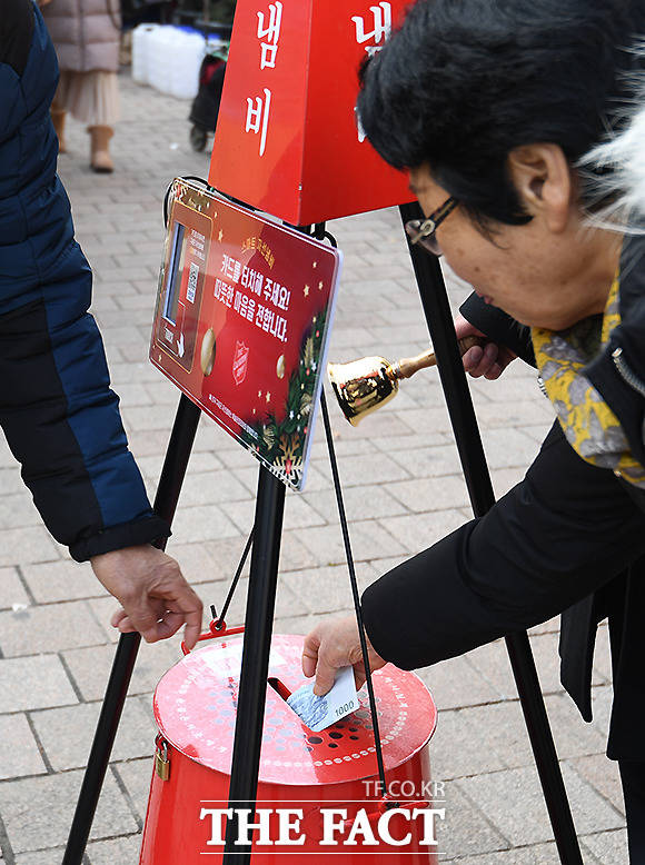 크리스마스 이브인 24일 오후 서울 중구 명동을 찾은 시민들이 자선 냄비에 돈을 넣고 있다. /이새롬 기자