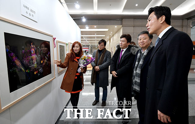 제3회 더팩트 사진 공모전 사진이 더 팩트다! 시상식이 26일 오후 서울 강남구 삼성동 코엑스 무역센터에서 열린 가운데 대상을 받은 윤위정 씨(왼쪽)가 작품 연꽃연가 앞에서 내빈들에게 사진 소개를 하고 있다. /이덕인 기자