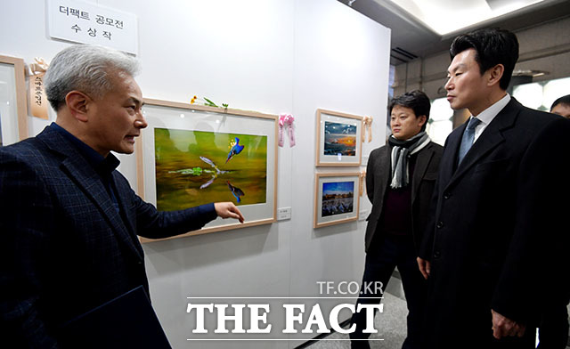 디지털카메라부문 최우수상을 받은 김용천 씨(왼쪽)가 내빈들에게 작품 위기탈출을 소개하고 있다.
