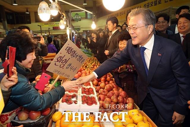 문재인 대통령이 3월 22일 대구시 북구 칠성종합시장에서 한 상인과 악수하는 모습. /청와대 제공