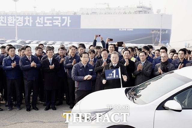 문재인 대통령이 3일 오전 경기 평택시 평택항에서 2020년 친환경차 수출 1호 니로에 기념 깃발을 달고 있다. /청와대 제공