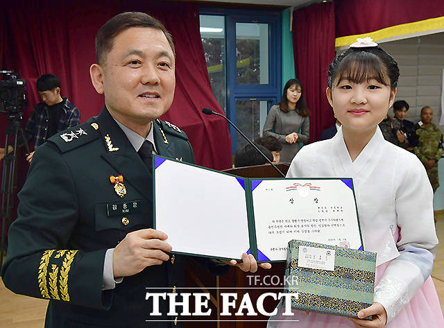 김종문 군사정전위원회 한국대표가 한 졸업생에게 상장을 수여하고 있다.