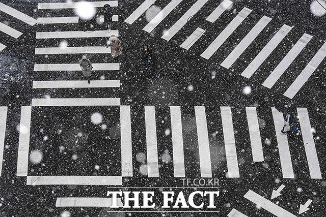 전국 대부분 지역에 눈이 내린 17일 오전 서울 중구 시청역 인근의 직장인들이 발걸음을 재촉하고 있다. /이동률 기자