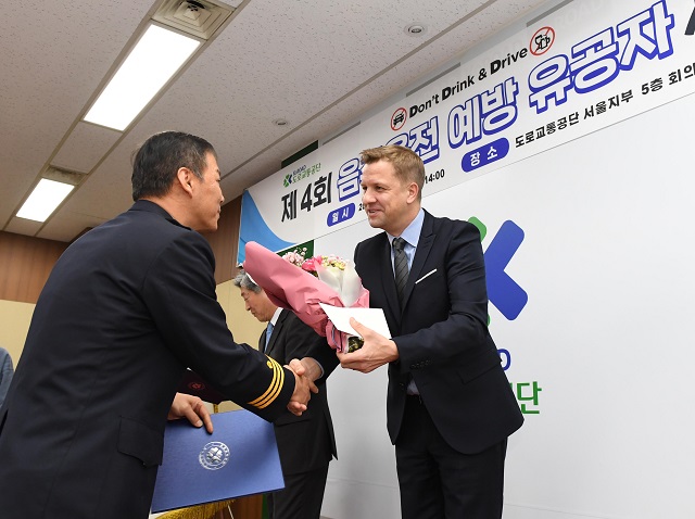 오비맥주가 음주운전 예방 켐페인의 일환으로 음주운전 예방에 공헌한 경찰관, 교통유관기관 관계자 등 총 15명을 선정해 포상하는 자리를 마련했다. 사진은 벤 베르하르트(배하준) 오비맥주 대표가 17일 서울 서초구 도로교통공단 서울지부에서 열린 제4호 음주운전 예방 유공자 시상식에서 경찰관에게 꽃과 시상금을 수여하고 있는 모습. /오비맥주 제공