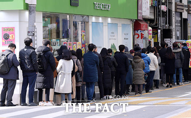 코로나19 여파로 마스크 5부제가 시행되고 있는 가운데 13일 오후 서울 중구의 한 약국 앞에서 시민들이 공적 마스크를 구매하기 위해 줄 서 있다. /이선화 기자