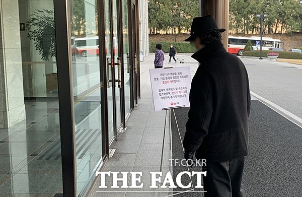 20일 농심 주총 참석자가 건물 내부로 진입하기 전 마스크 출입 등을 안내하는 간판을 읽고 있다. /동작=이민주 기자