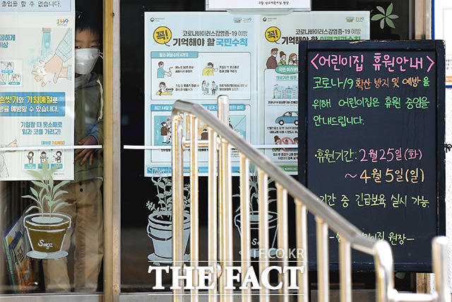 전국 어린이집 개원 시기가 무기한 연기된 가운데 1일 오전 서울 동작구의 한 어린이집에서 긴급보육을 받는 어린이가 마스크를 쓰고 문 밖을 바라보고 있다. /이선화 기자