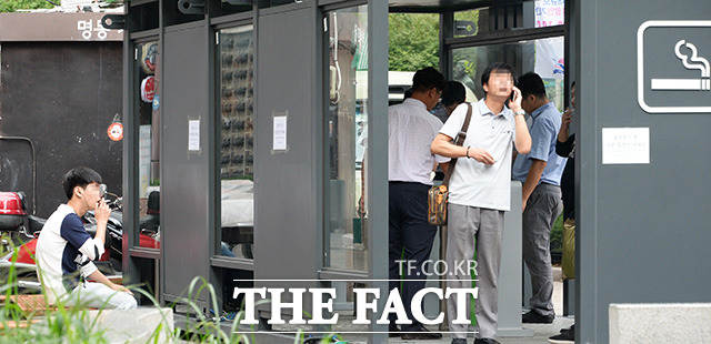 정부가 4일 흡연자를 코로나19 고위험군에 추가했다. 사진은 서울 중구 명동거리 흡연 금지구역 밖에서 한 시민이 담배를 피우고 있는 모습. /더팩트 DB